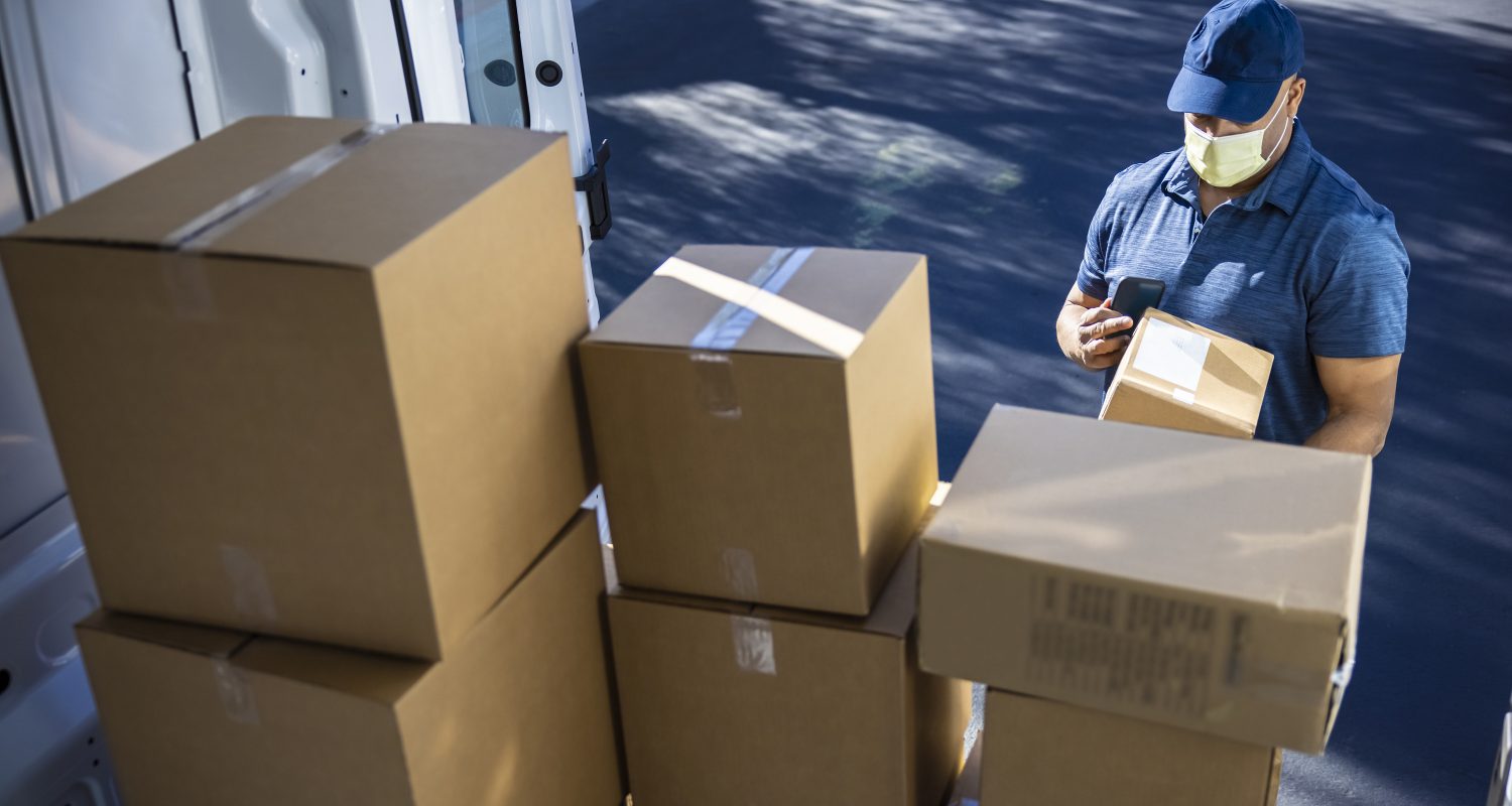 Man making deliveries from his cargo van on a sunny day.