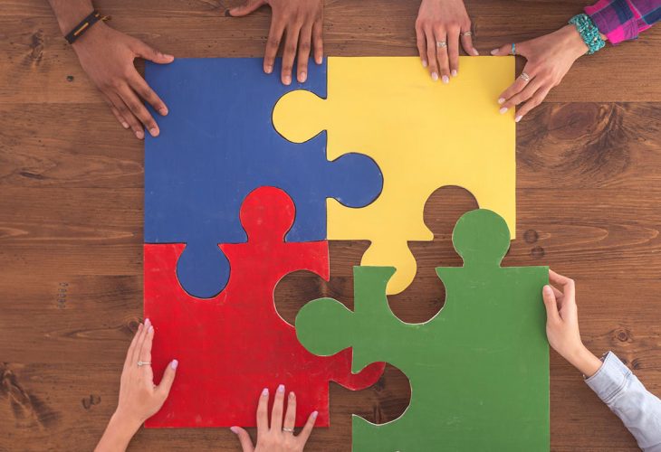 hands putting together a puzzle