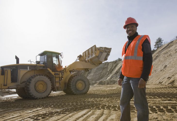 Engineer at a construction site with a front-end loader in the background